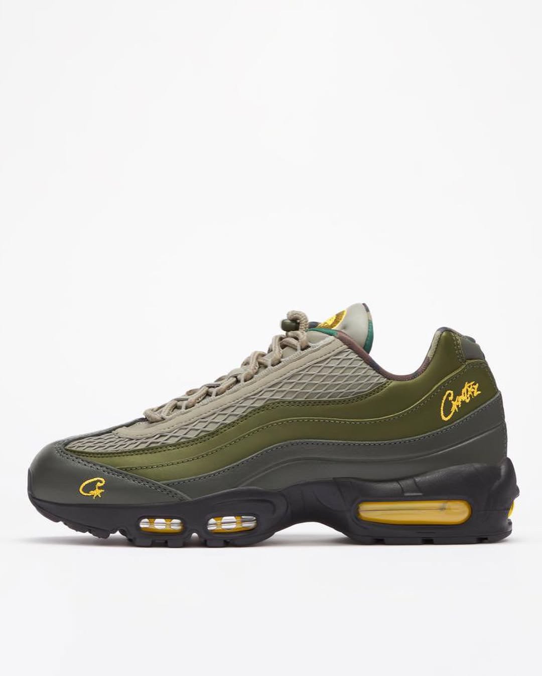 Green sneaker with yellow accents on a white background