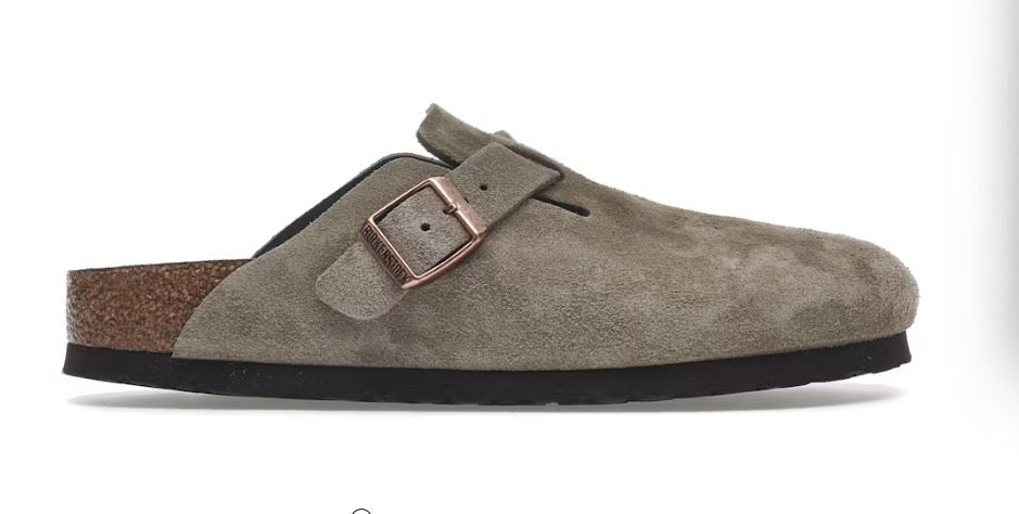 Brown suede clog shoe with a buckle on a white background