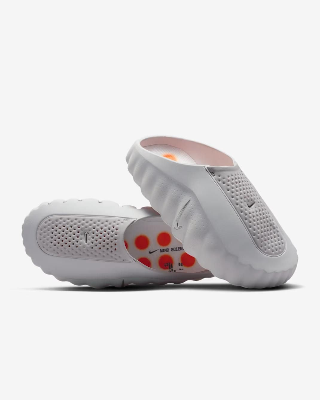 White Nike clogs with red paw print design on a white background